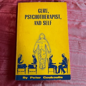 May include: A vintage book titled "GURU, PSYCHOTHERAPIST, AND SELF" with a yellow cover and blue text. The cover features illustrations of figures and the author's name, Peter Coukoulis. The book is set against a red background.