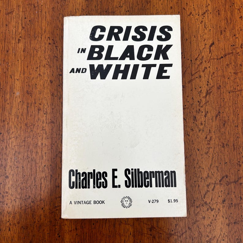 May include: A paperback book titled Crisis in Black and White by Charles E. Silberman. The cover is white with bold black text. It features the Vintage Books logo, the code V-279, and a price of $1.95 printed at the bottom of the front cover.