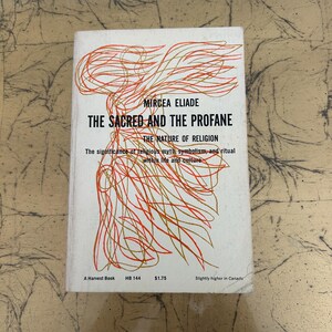 May include: A white paperback book titled The Sacred and the Profane: The Nature of Religion by Mircea Eliade. The cover features an abstract orange and yellow line drawing, with black text detailing the subtitle and publisher information.