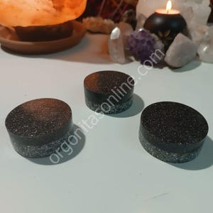 Pode incluir: Três  apoios de copo redondos preto e branco salpicados com uma superfície lisa e polida.