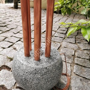 Peut inclure: Un lampadaire avec une base ronde en granit gris et quatre tuyaux en cuivre s'étendant vers le haut.