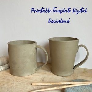 Op de afbeelding: Twee keramische mokken, een met een rechte zijde en een met een gebogen zijde, beide met handvatten. De mokken zijn lichtbruin van kleur en staan op een houten oppervlak. De tekst "Printable Template Digital Download" is in het blauw geschreven op een witte achtergrond.