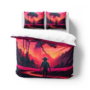 Peut inclure: Une housse de couette avec une illustration colorée d'une personne debout dans un paysage avec une grande créature à plusieurs pattes en arrière-plan. La créature descend du ciel et a une palette de couleurs rouge, orange et jaune. La personne porte une combinaison spatiale et regarde la créature.