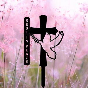 May include: Black metal silhouette of a cross with a dove flying up from the bottom. The cross is attached to a stake and the words "REST IN PEACE" are on a separate metal piece.