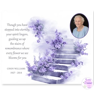 May include: A memorial print with a portrait of Cindy Williams, 1927-2014. The image shows a staircase decorated with purple flowers and a poem about remembrance. The background is a soft, ethereal purple, evoking a sense of peace.