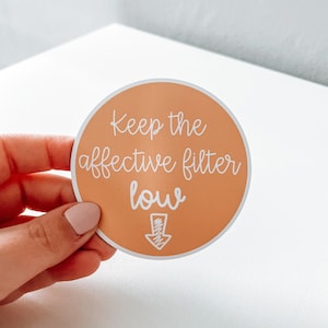 May include: A round sticker with an orange background and white text that reads "Keep the affective filter low" with a downward arrow.