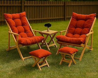 May include: Outdoor seating set featuring two wooden lounge chairs with rust-colored cushions, two matching footstools, and a small side table. The chairs and footstools are on a green lawn, with a wooden fence in the background.