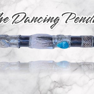 May include: A silver and black pendulum with a white feather, turquoise stone, and the words "The Dancing Pendulum" above it.