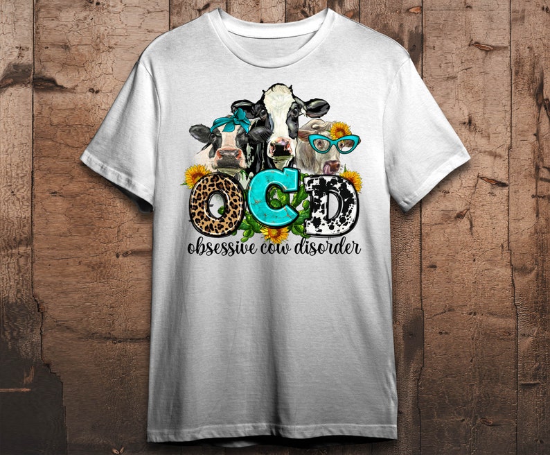 May include: White t-shirt featuring a graphic of three cows with sunflowers and the text "OCD obsessive cow disorder." The letters "OCD" are styled with a leopard print, turquoise, and a black and white cow pattern.