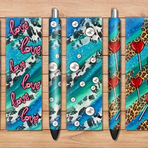 Puede incluir: Conjunto de seis bolígrafos con diferentes diseños. Los diseños incluyen un patrón azul y blanco con la palabra "love" repetida, un patrón azul y blanco con perlas, un patrón azul y blanco con estampado de leopardo y un patrón azul y blanco con piruletas de corazón rojo.