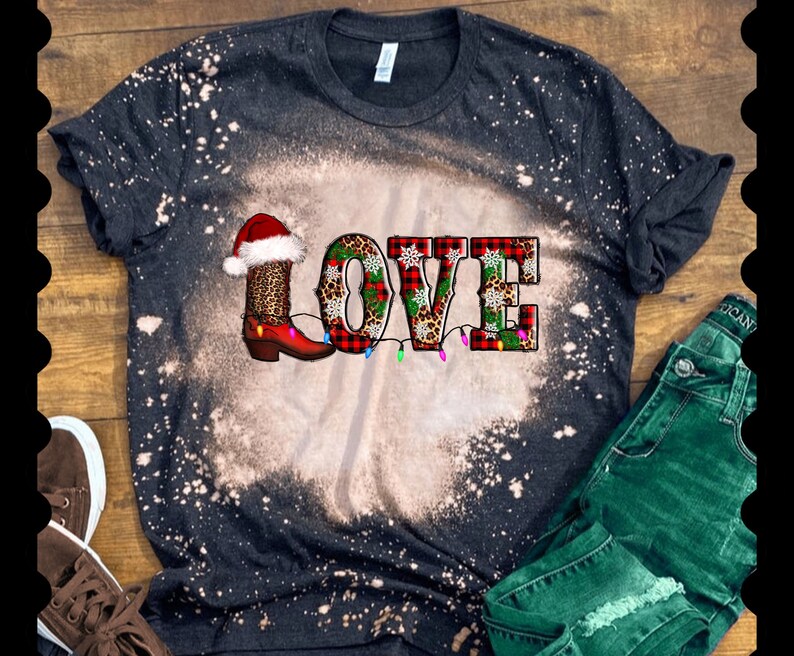 May include: Black bleached t-shirt with a red, green, and white "LOVE" graphic featuring a Christmas boot, snowflakes, and lights.