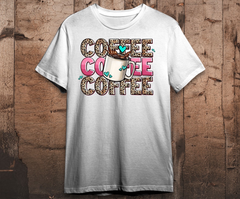 May include: White t-shirt with a graphic of a coffee cup with hearts and the text "COFFEE" repeated three times.