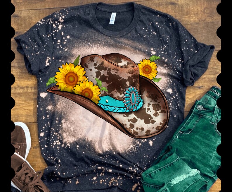 May include: A black t-shirt with a bleached effect featuring a brown and white cow print cowboy hat with a turquoise band and sunflowers.