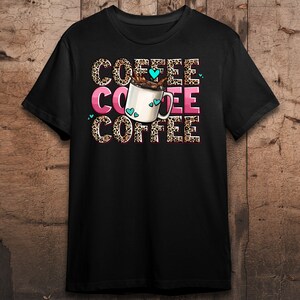 May include: Black t-shirt with a graphic of a coffee cup with hearts and the word "COFFEE" repeated three times in a leopard print pattern.