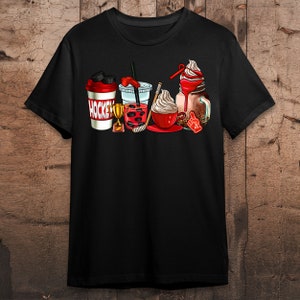 May include: Black t-shirt with a graphic of a hockey stick, a trophy, a shaker bottle, and four different types of drinks. The shaker bottle says "HOCKEY" on it.