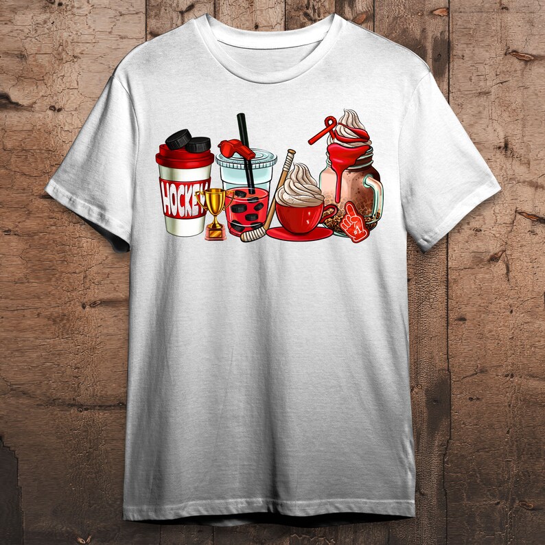 May include: White t-shirt with a graphic of a hockey stick, a trophy, and various beverages including a coffee cup, a boba tea, and a milkshake. The text "HOCKEY" is printed on the side of a red and white cup.