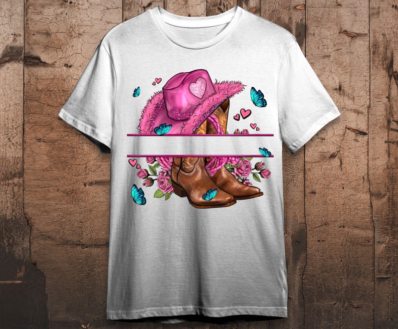 Puede incluir: Camiseta blanca con un sombrero vaquero rosa, botas vaqueras marrones, flores rosas y mariposas azules. El sombrero tiene un dise&ntilde;o de coraz&oacute;n en la parte delantera.