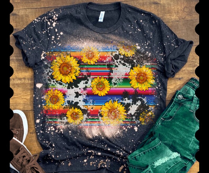 May include: A black t-shirt with a bleach-splattered design featuring a colorful striped pattern and yellow sunflowers.