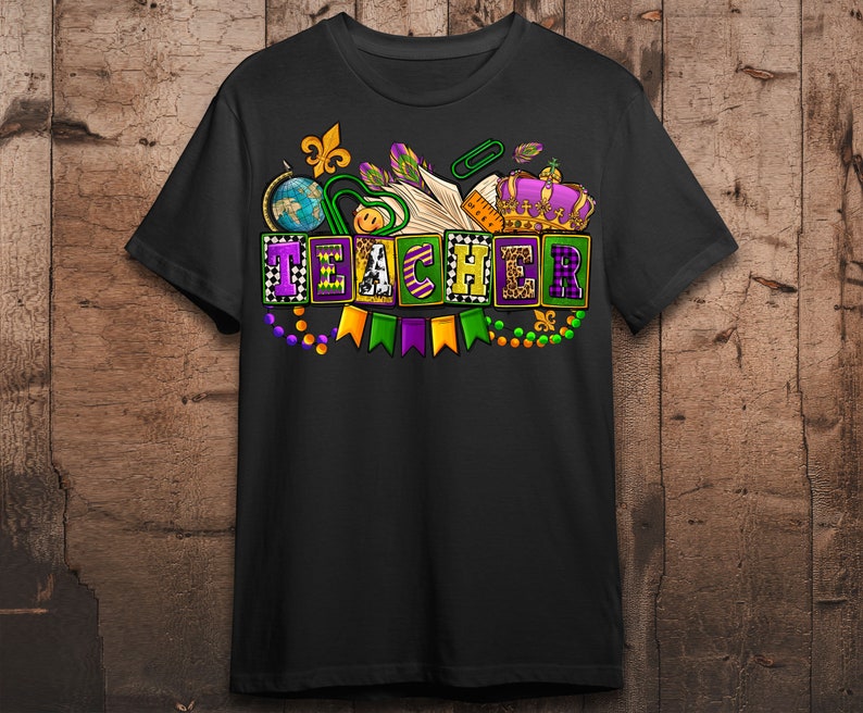May include: Black t-shirt with a Mardi Gras themed design featuring the word "TEACHER" in colorful blocks with beads, flags, and a crown.