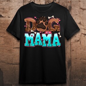 May include: Black t-shirt featuring a graphic design of a paw print and the text "Dog Mama" in colourful letters with a leopard print background.