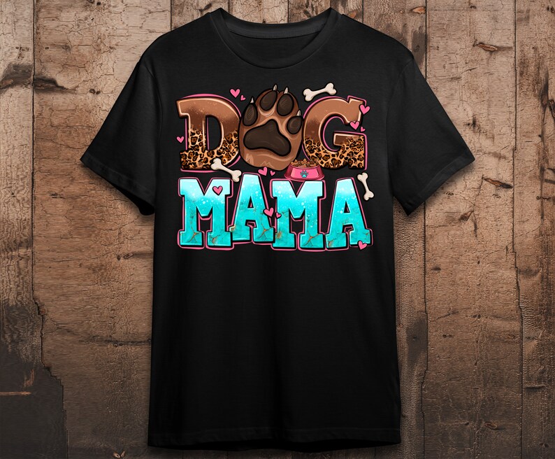 May include: Black t-shirt featuring a graphic design of a paw print and the text "Dog Mama" in colourful letters with a leopard print background.