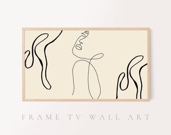 May include: A minimalist line art print featuring a black line drawing of a face and abstract shapes on a beige background. The print is framed in a light wood frame.