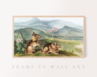 May include: A vintage illustration of two brown rabbits in a grassy field with pink flowers. The rabbits are facing different directions, and the background features a watercolor depiction of mountains and a lake.