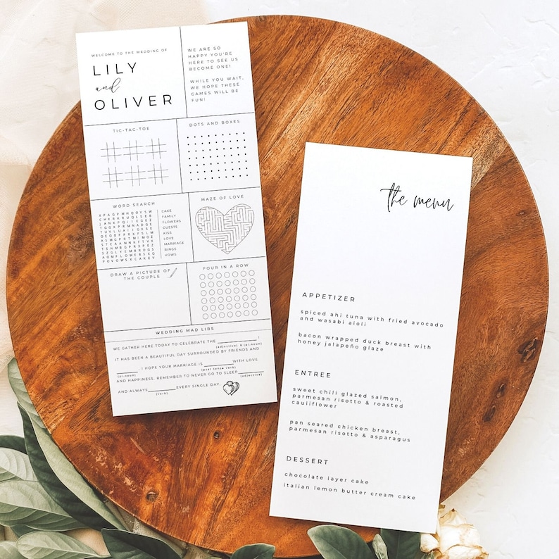 May include: A wedding menu card with the title "The Menu" printed in black script font. The menu features a three-course meal with appetizers, entree, and dessert. The appetizers are spiced ahi tuna with fried avocado and wasabi aioli, and bacon wrapped duck breast with honey jalape&ntilde;o glaze. The entree is sweet chili glazed salmon, parmesan risotto & roasted cauliflower, and pan seared chicken breast, parmesan risotto & asparagus. The dessert is chocolate layer cake and Italian lemon butter cream cake.