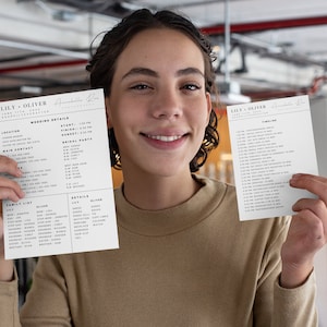May include: A person holding two sheets of paper with wedding details. The first sheet lists wedding details, including the location, start time, sunset time, and bridal party. The second sheet lists a wedding timeline with times and events.