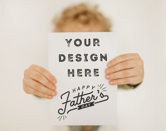 May include: A white card with the text "YOUR DESIGN HERE" and "HAPPY FATHER'S DAY" in black lettering. A child is holding the card in front of their face.