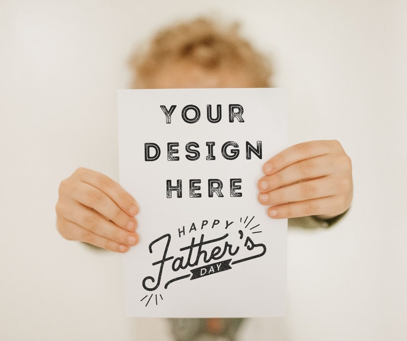 May include: A white card with the text "YOUR DESIGN HERE" and "HAPPY FATHER'S DAY" in black lettering. A child is holding the card in front of their face.