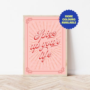 Può includere: Un poster rosa con una grafica rossa e bianca che dice "Spice up your life" con un design a raggiera. Il poster è incorniciato in una cornice di legno chiaro.