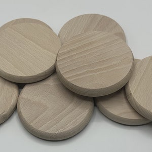 Könnte beinhalten: Ein Stapel von acht unfertigen, runden Holz-Untersetzern. Die Untersetzer sind hellbraun und haben eine glatte, leicht strukturierte Oberfläche.