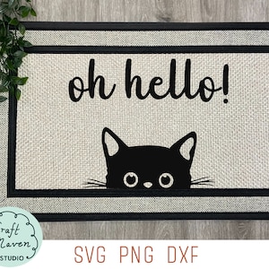 Könnte beinhalten: Eine Willkommensmatte mit einer schwarzen Katze, die hinter dem Text "oh hello!" hervorlugt. Die Matte hat einen beigefarbenen Hintergrund mit einem schwarzen Rand.