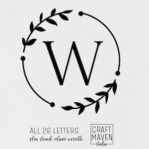 May include: Black and white monogram design featuring the letter W surrounded by a wreath of leaves. The design includes the text "ALL 26 LETTERS plus stand-alone wreath" and "CRAFT MAVEN studio".