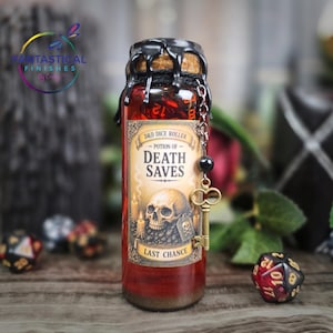 May include: A glass bottle labeled "Potion of Death Saves" with a skull graphic, designed for D&D dice rolling. The bottle has a cork top sealed with black wax and a decorative chain with a key charm. The potion is red, and the label reads "Last Chance".
