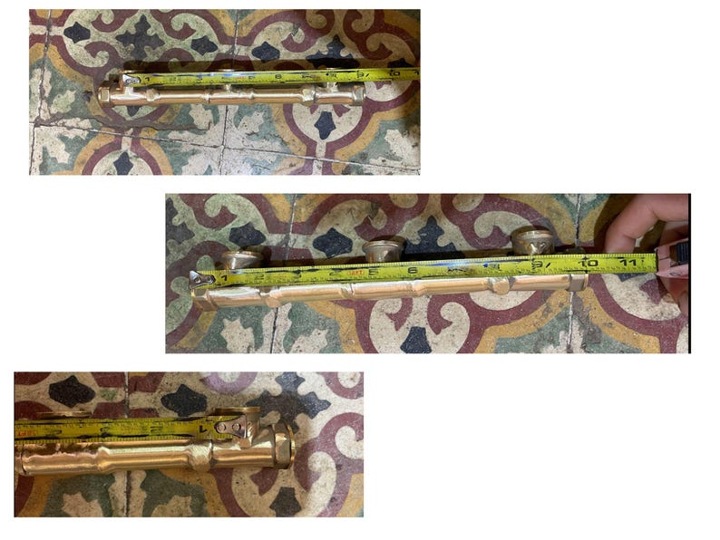 May include: A brass door handle, approximately 10 inches long, is shown with a yellow measuring tape. The handle has a bamboo-like design with three circular knobs. The background is a patterned tile surface.