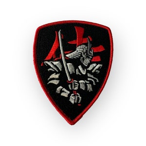 May include: Embroidered patch with a shield shape, featuring a samurai skeleton holding a katana. The design includes red Japanese characters and a red border on a black background. The samurai is depicted in white and gray.