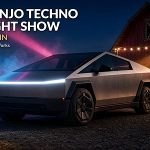 May include: A silver angular electric pickup truck with a prominent horizontal LED headlight strip. The text BANJO TECHNO LIGHT SHOW ~4 MIN SecristWorks is visible. The vehicle features dark geometric wheel covers and a sharp, wedge-shaped body design.
