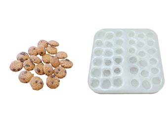 May include: A white silicone mold with 36 round cavities, perfect for making small cookies or candies. A pile of chocolate chip cookies is shown next to the mold.
