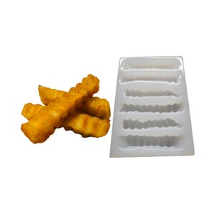 May include: A close-up of golden-brown crinkle-cut fries with a silicone mold. The fries are seasoned and appear crispy. The mold has six cavities, each shaped like a crinkle-cut fry.