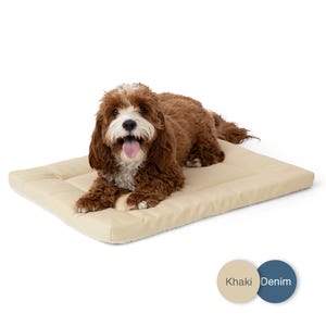 May include: A rectangular pet bed with a smooth, light beige surface and a quilted border. The bed features a soft, textured underside. Two circular color swatches are visible in the corner, labeled Khaki and Denim, indicating available options.