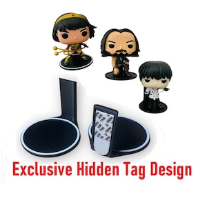 May include: Three black 3D printed display stands for Funko Pop figures. Each stand has a hidden tag design. The stands are shown with three Funko Pop figures: a woman with a red and gold costume, a man with a black leather jacket and a man with a white shirt and black pants.