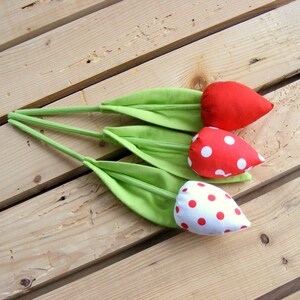 May include: Three handmade fabric tulips with green stems and red and white polka dot fabric flowers.