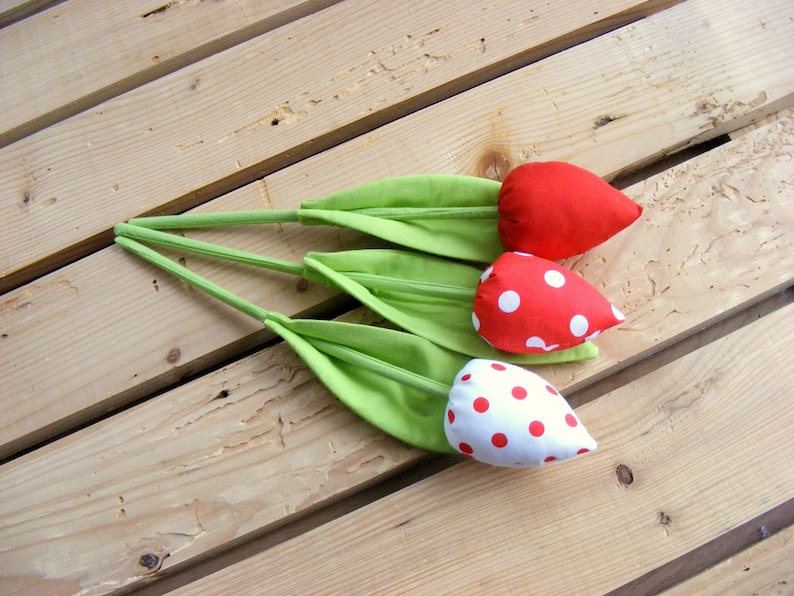 May include: Three handmade fabric tulips with green stems and red and white polka dot fabric flowers.