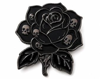 Puede incluir: Un broche de esmalte negro con forma de rosa que tiene cinco pequeñas calaveras plateadas incrustadas en los pétalos. La rosa presenta pétalos superpuestos y dos hojas en la base, todo delineado con un acabado metálico oscuro y detallado.