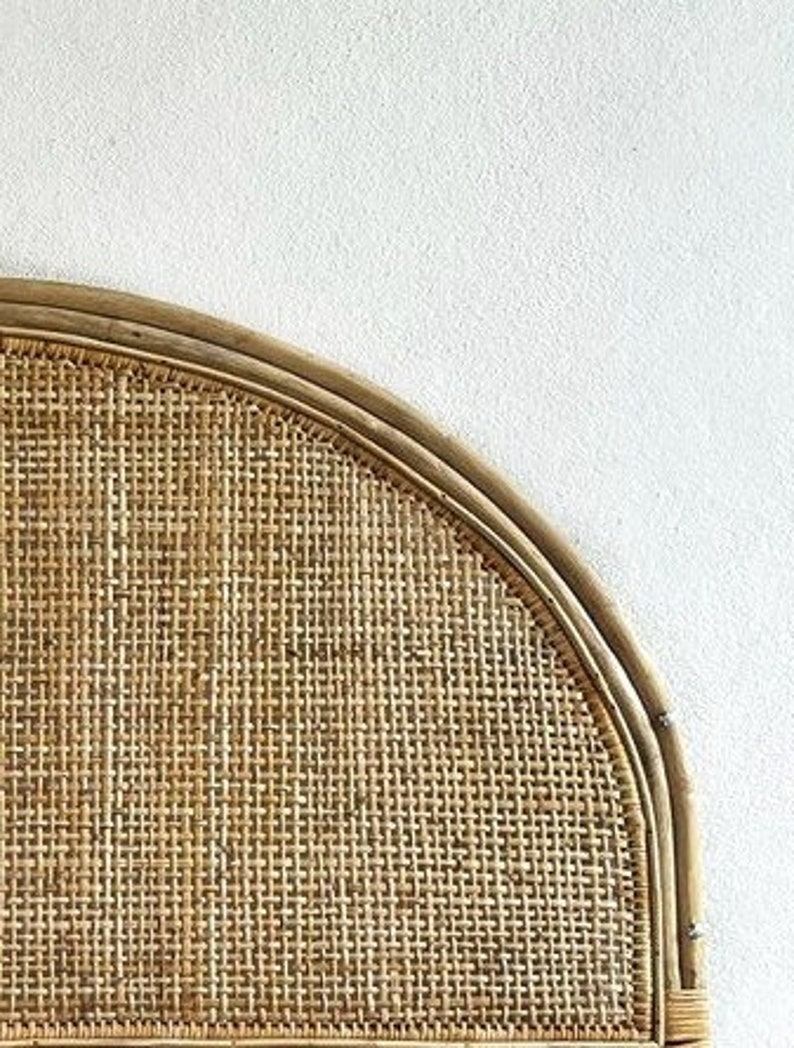 May include: A half-round headboard made of woven rattan with a natural brown color.