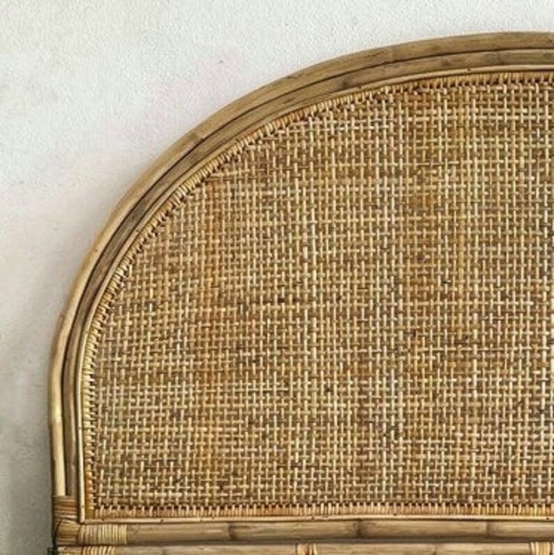 May include: A natural woven headboard with a curved top and a woven rattan design.