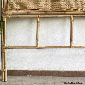 May include: A natural woven headboard with a bamboo frame. The headboard has a woven rattan panel and a simple design.