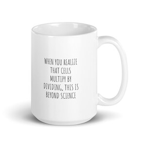 May include: White ceramic coffee mug with a black text design that reads "When you realize that cells multiply by dividing, this is beyond science."